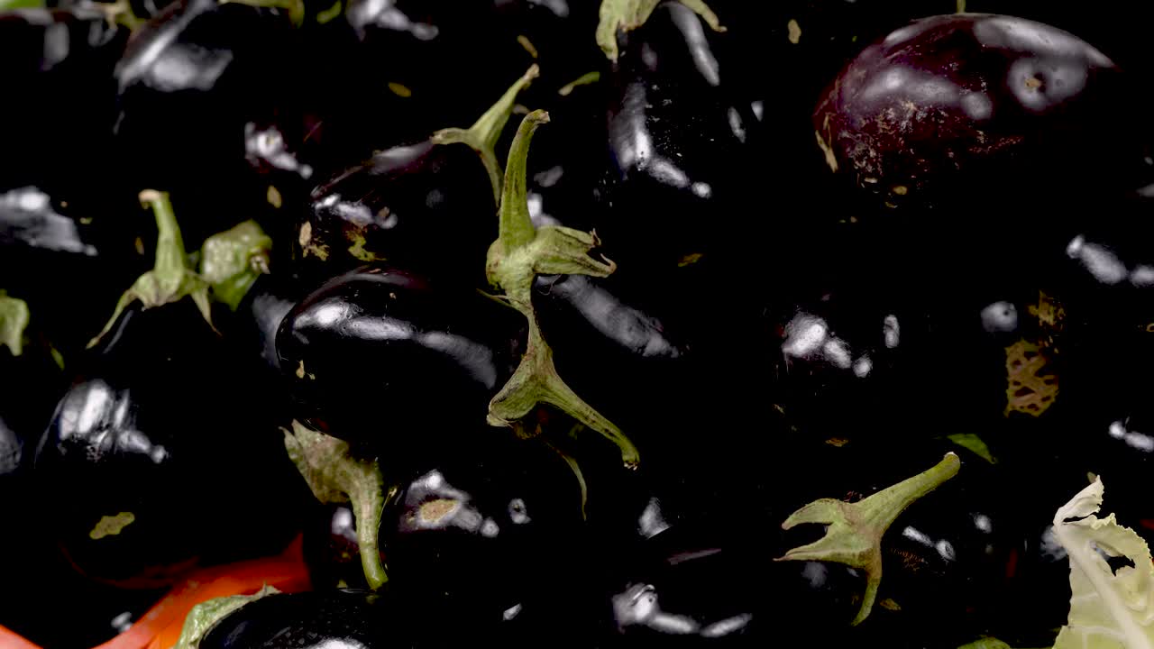 A colorful market brims with fresh produce, showcasing glossy black eggplants piled high. Vibrant colors and enticing aromas fill the air