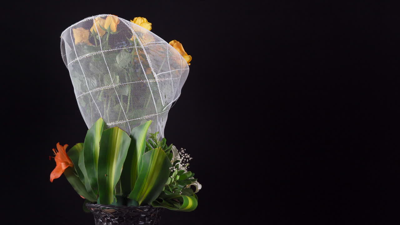 Gule roser, liljer og gerbera blomsterarrangement som spinner og panorerer i en slider på svart bakgrunn