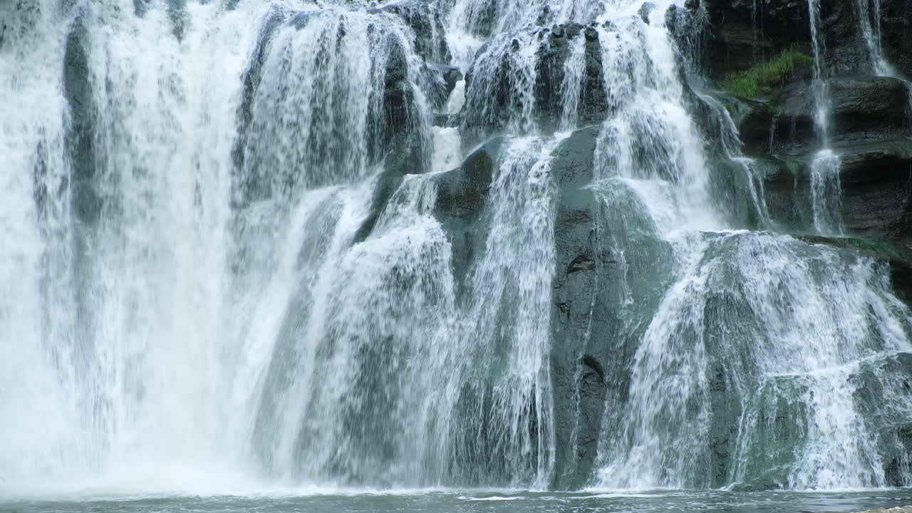 A waterfall cascades in a tropical rainforest with rock