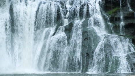 a waterfall cascades in a tropical rainforest with rock