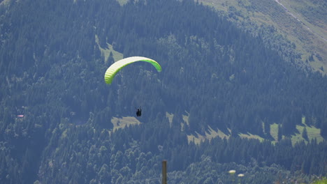 a parachute twirls while descending in the plain of engelberg, obwalden in the swiss alps