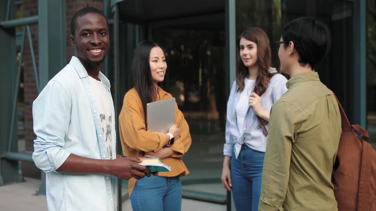 Group of multiethnic students talking in the street near the college in a break