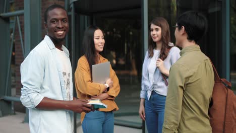 group of multiethnic students talking in the street near the college in a break