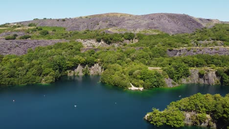 aerial view dorothea flooded slate mining quarry woodland in snowdonia valley with gorgeous shimmering turquoise lake