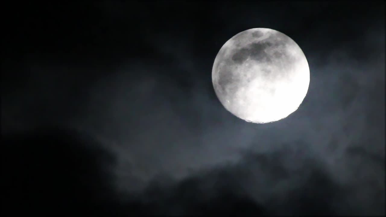 Finas camadas de nuvens passando pela lua cheia, lua e nuvens muito brilhantes.