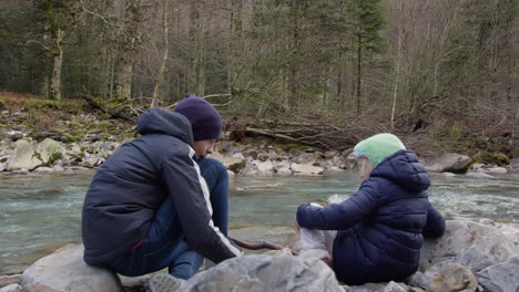 siblings playing by a river in a winter forest