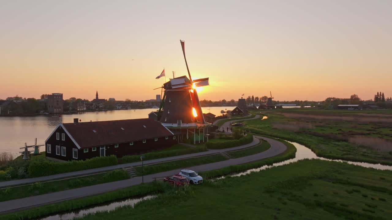 Luftaufnahme von ikonischen niederländischen Mühlen, die sich bei Sonnenuntergang während der Königstagsfeier drehen