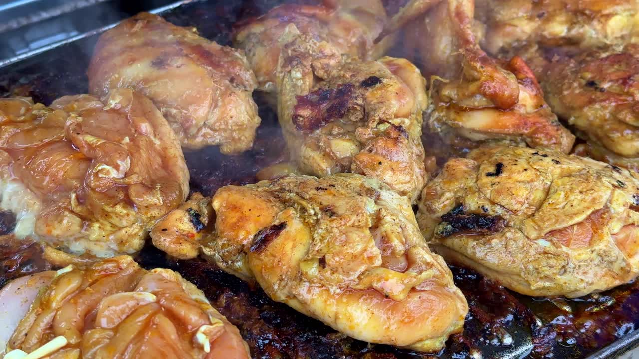 el pollo cocinado en una parrilla está caliente y emite humo.