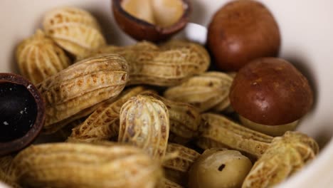 Assorted nuts and peanuts in a white bowl