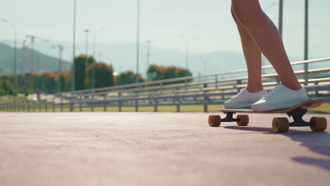 mujer patinando en longboard en el parque de la ciudad