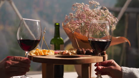 couple toasting with wine glasses and cheese board