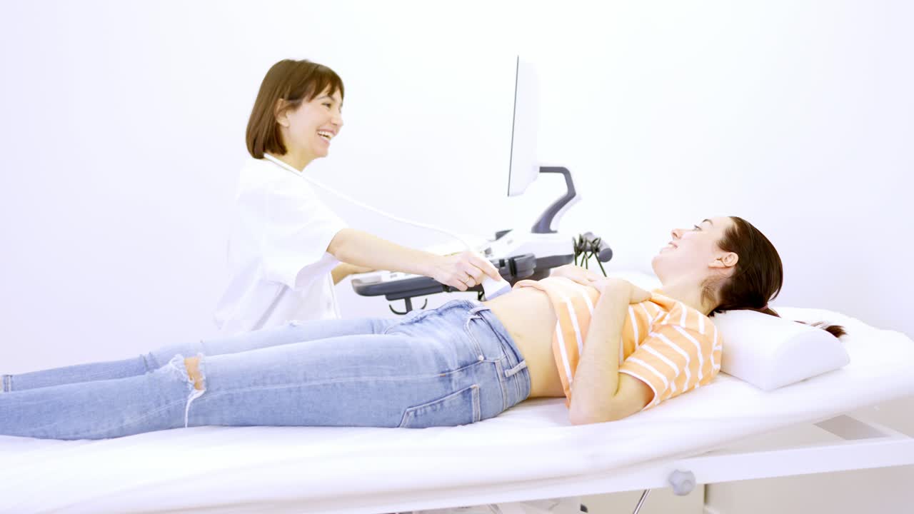 Doctor informs a patient that she is pregnant during ultrasound