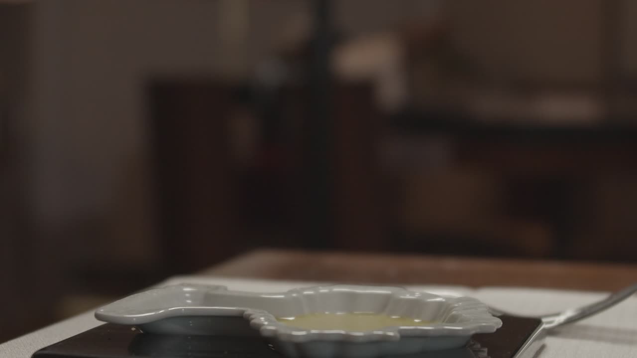 웨이터는 식탁에 있는 레스토랑에서 올리브 오일에 소금을 넣습니다.