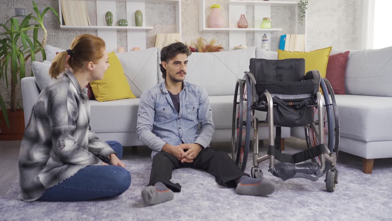 장애인 청년과 그의 여자친구가 집에서 대화를 나누고 있습니다.