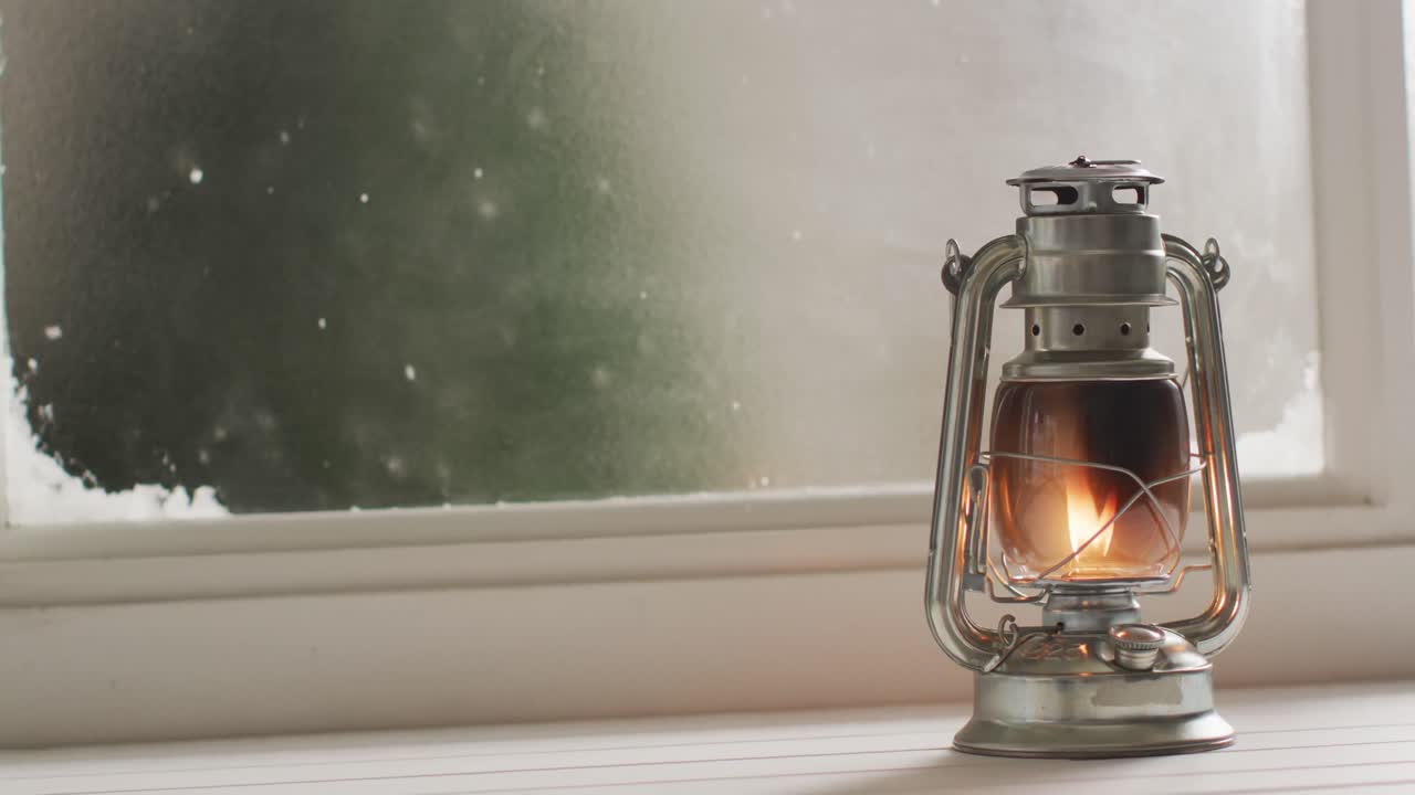 얼어붙고 눈  ⁇ 인 창문 위에서 반 ⁇ 이는 빈티지 오일 램프의 비디오
