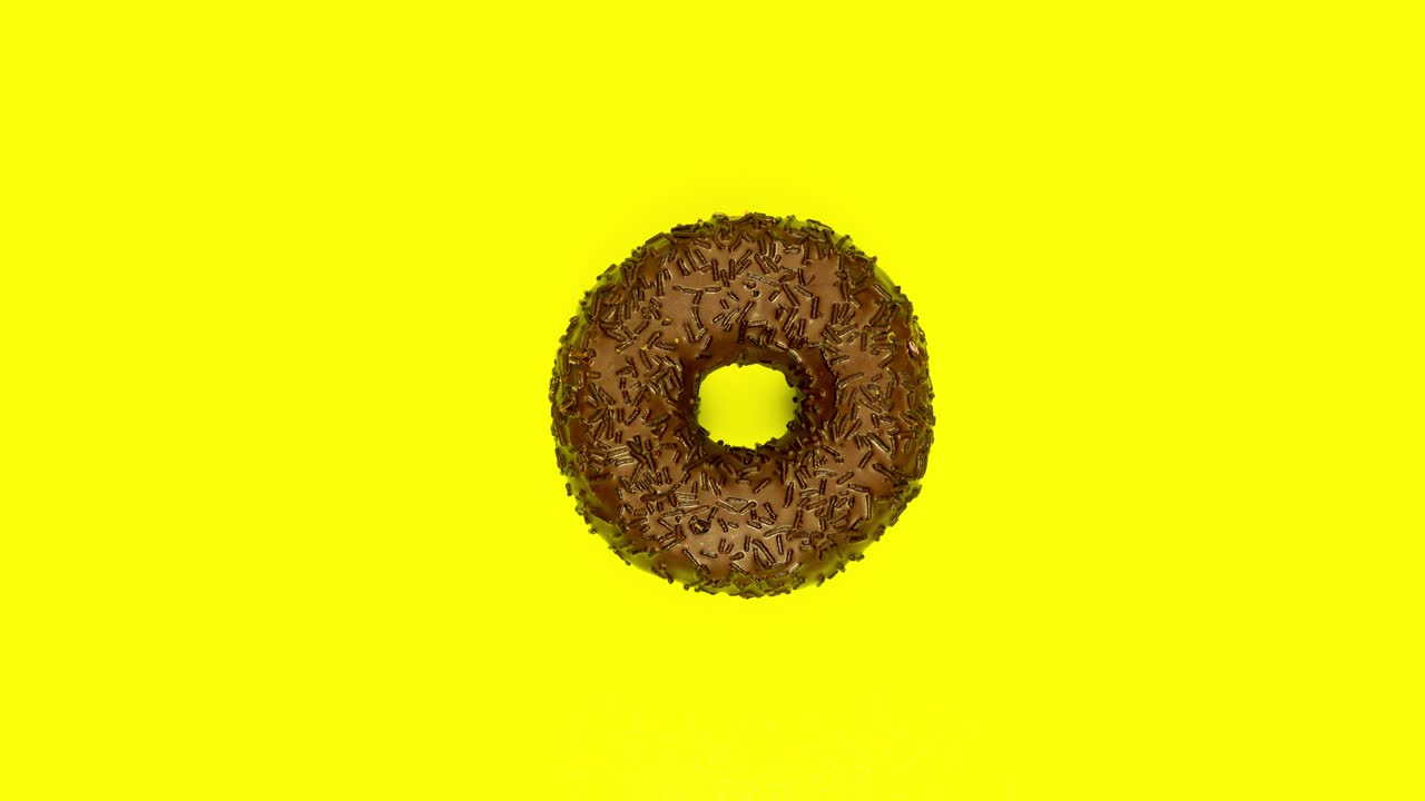Stop motion animation. Chocolate donut spinning on yellow background