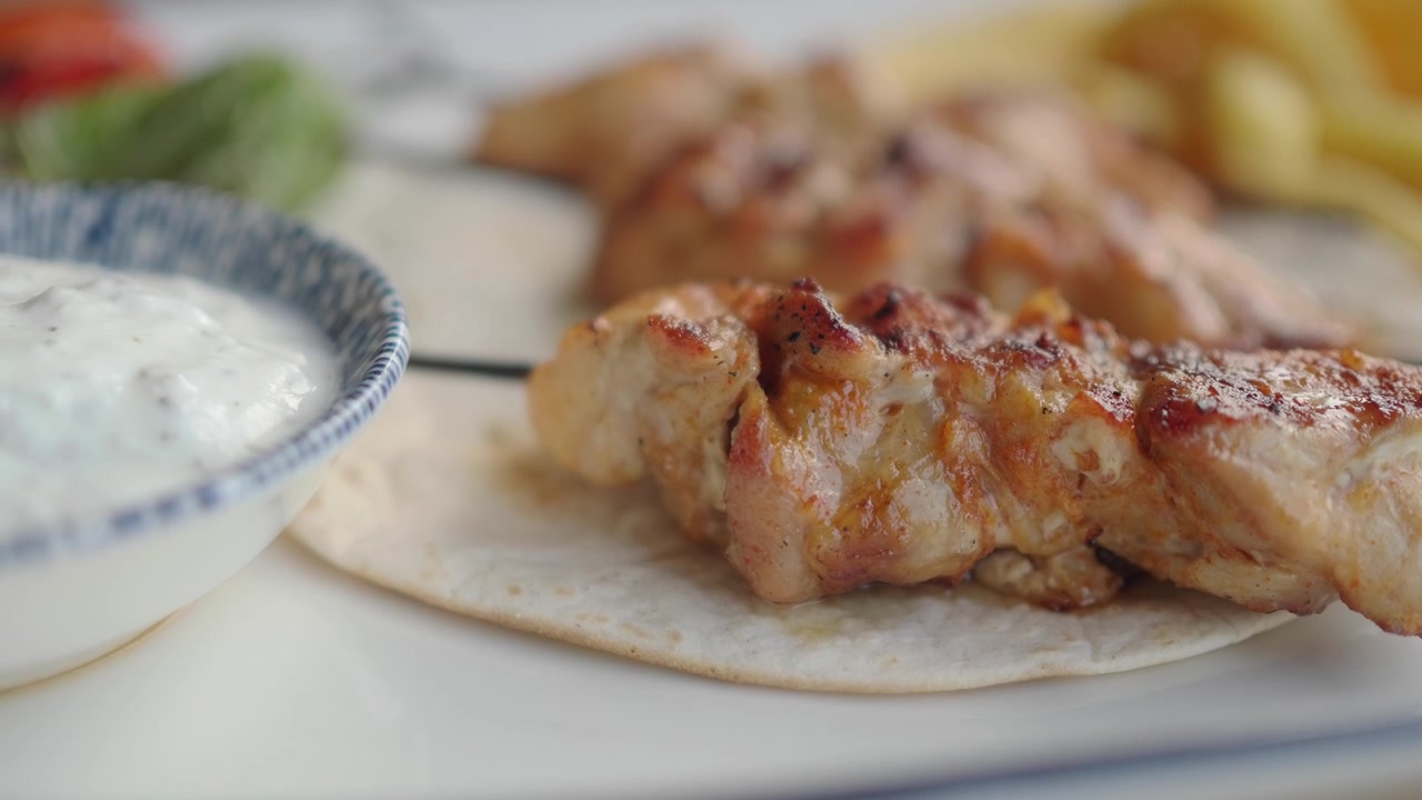 Primo piano di spiedino di pollo grigliato con tortilla e salsa