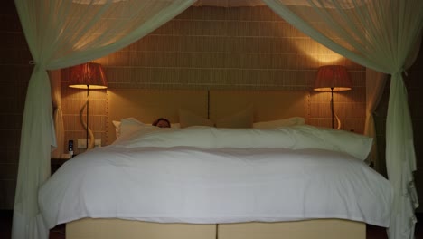 mujeres entrando en una cama de hotel de lujo perfectamente hecha