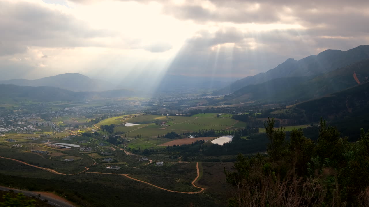 Ethereal god rays fall over Franschhoek valley in Cape winelands, lookout view