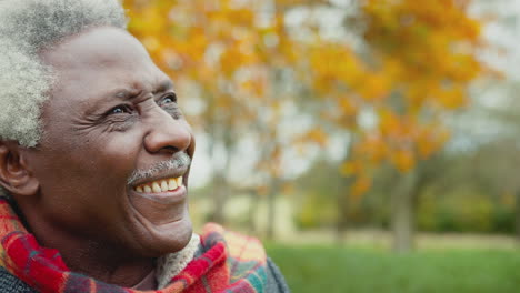 head and shoulders portrait of senior man on walk through autumn countryside - shot in slow motion