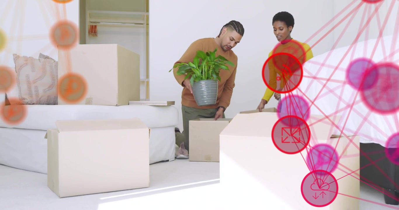 Casal desempacotando caixas de mudança e colocando luminária de latão e planta enquanto decora o espaço da sala de estar.