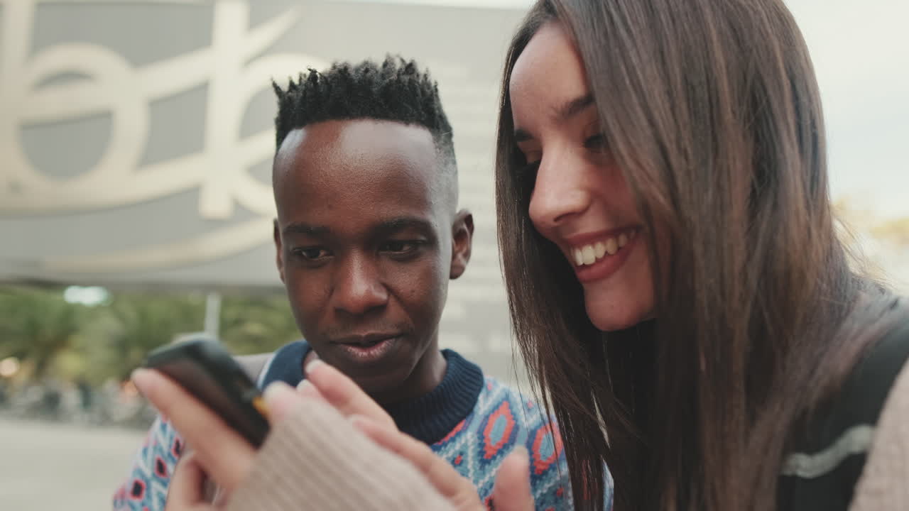 Two College Students Using a Mobile Phone Outdoors