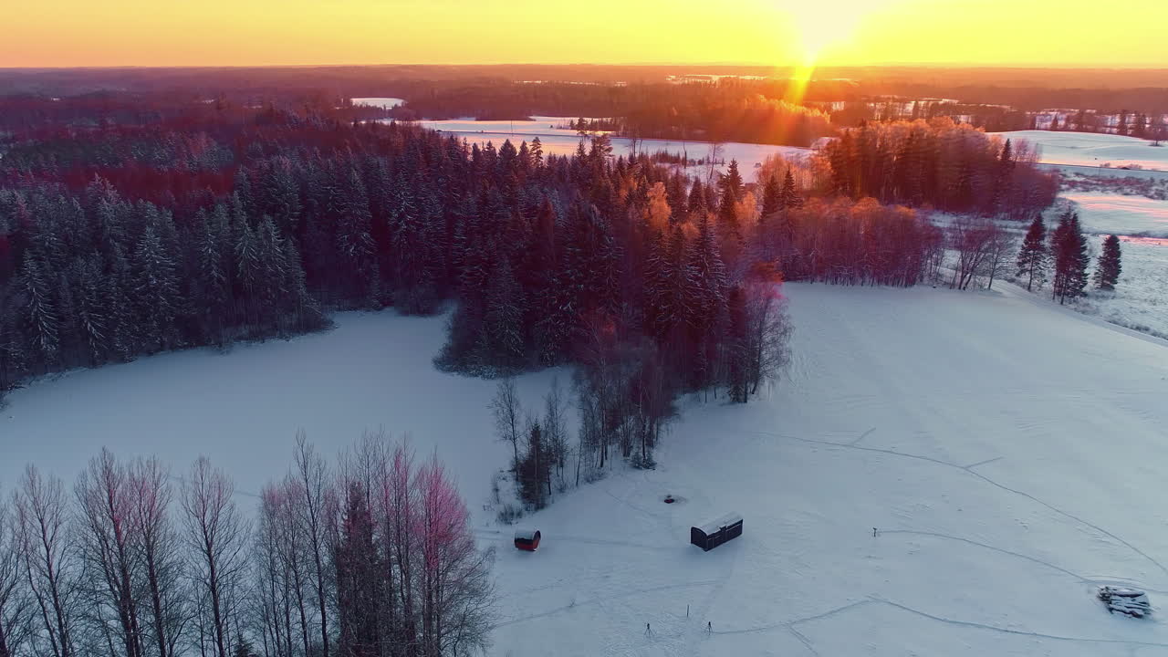 유럽 라트비아의 숲 나무와 함께 아름다운 눈 풍경 위에서 겨울 해가 지는 장면