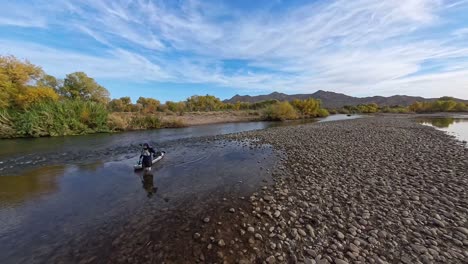 walking upriver pulling a paddleboard in the lower salt river in mesa arizona.