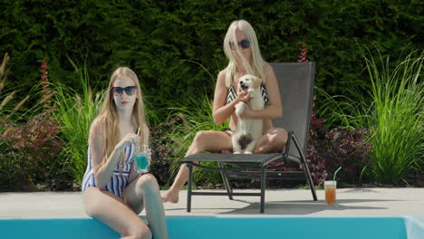 mom, daughter and puppy are relaxing by the pool. good time together, family vacation