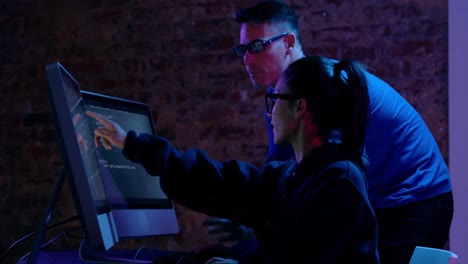 mujer y hombre trabajando juntos en computadoras