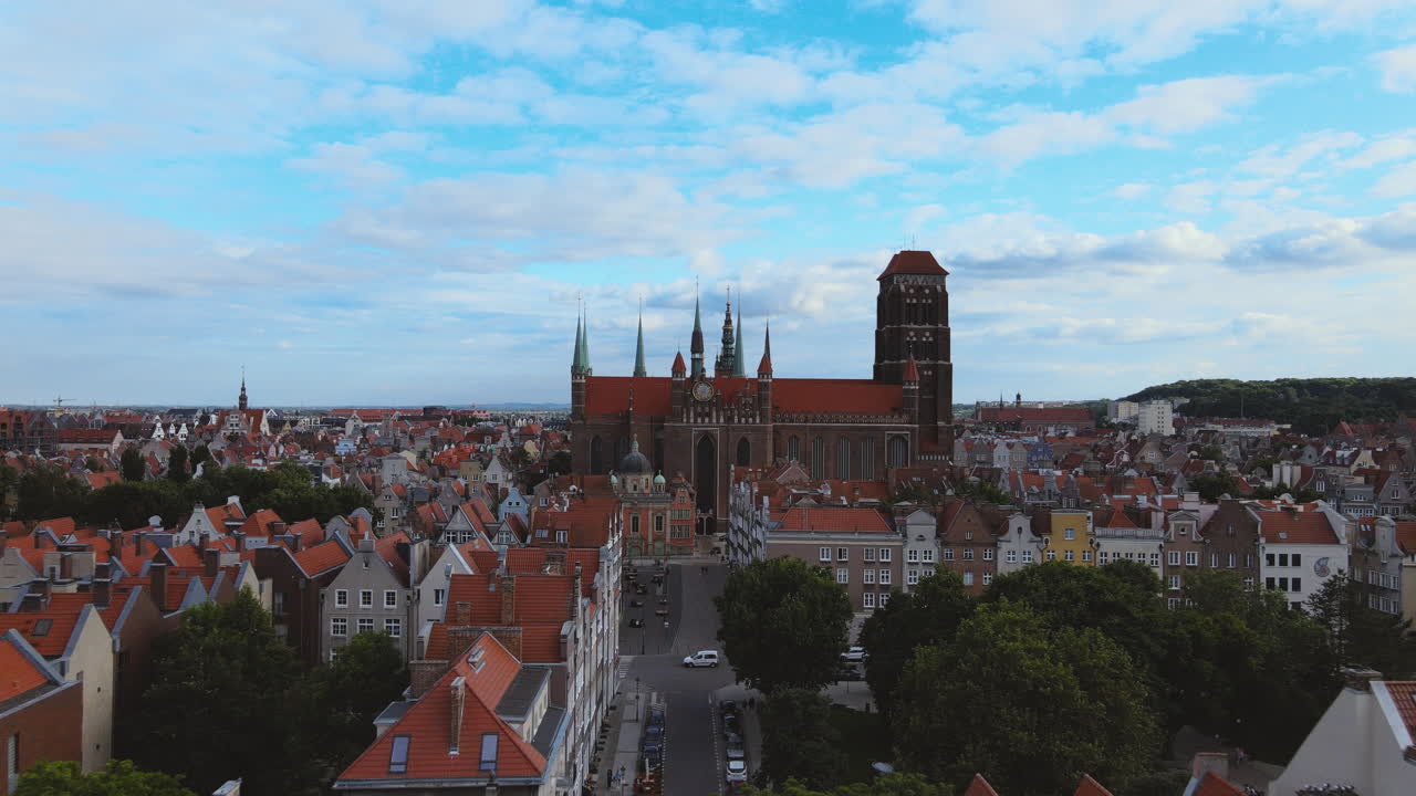 Aerial back fly view on St. Mary's Church in old Town Gdansk, Flight over the roofs of old townhouses