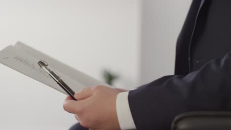 Close-Up-Of-Male-Candidate-Being-Called-In-For-Job-Interview-In-Office-By-Female-Interviewer