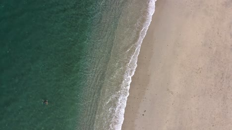 Olas-Rompiendo-En-La-Playa-Con-Gente-Nadando-Y-De-Pie,-Vista-Aérea