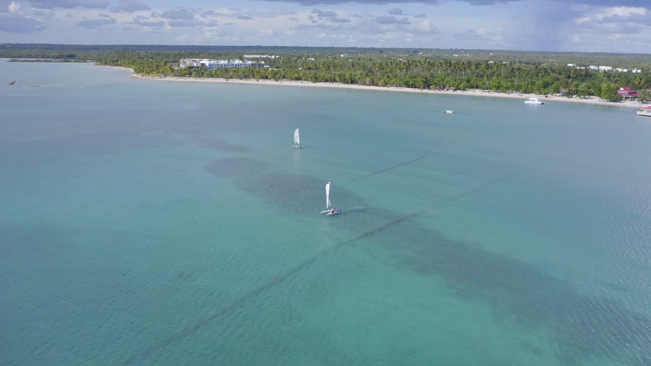 toma aérea en órbita de un catamarán de vela en el claro mar caribe en playa nueva romana en verano