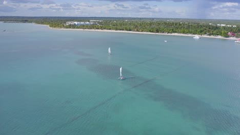 Aerial-orbiting-shot-of-sailing-Catamaran-on-clear-Caribbean-Sea-at-Playa-Nueva-Romana-in-summer