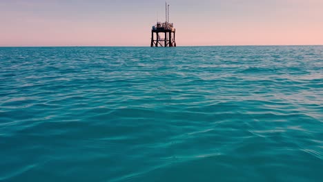 approaching an abandoned offshore oil platform or oil rig in open sea