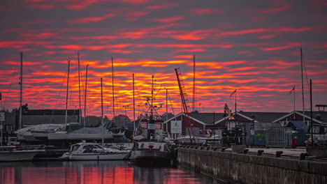 dramatic-burning-orange-cloudscape-over-a-harbor-deck-and-boats