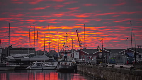 dramatic burning orange cloudscape over a harbor deck and boats