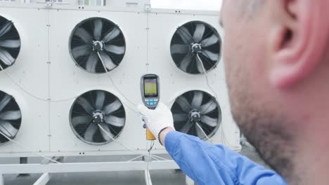 technician uses a thermal imaging infrared thermometer to check the condensing unit heat exchanger