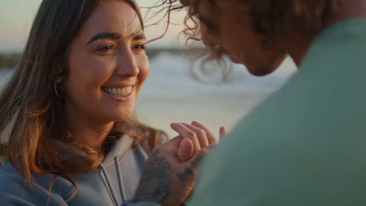 una pareja en la playa al atardecer.
