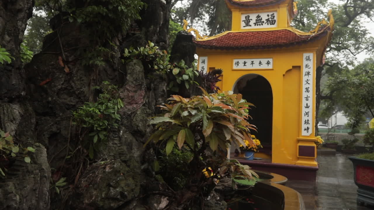 Rocky garden and traditional yellow temple building with intricate details in Sa Pa, Vietnam