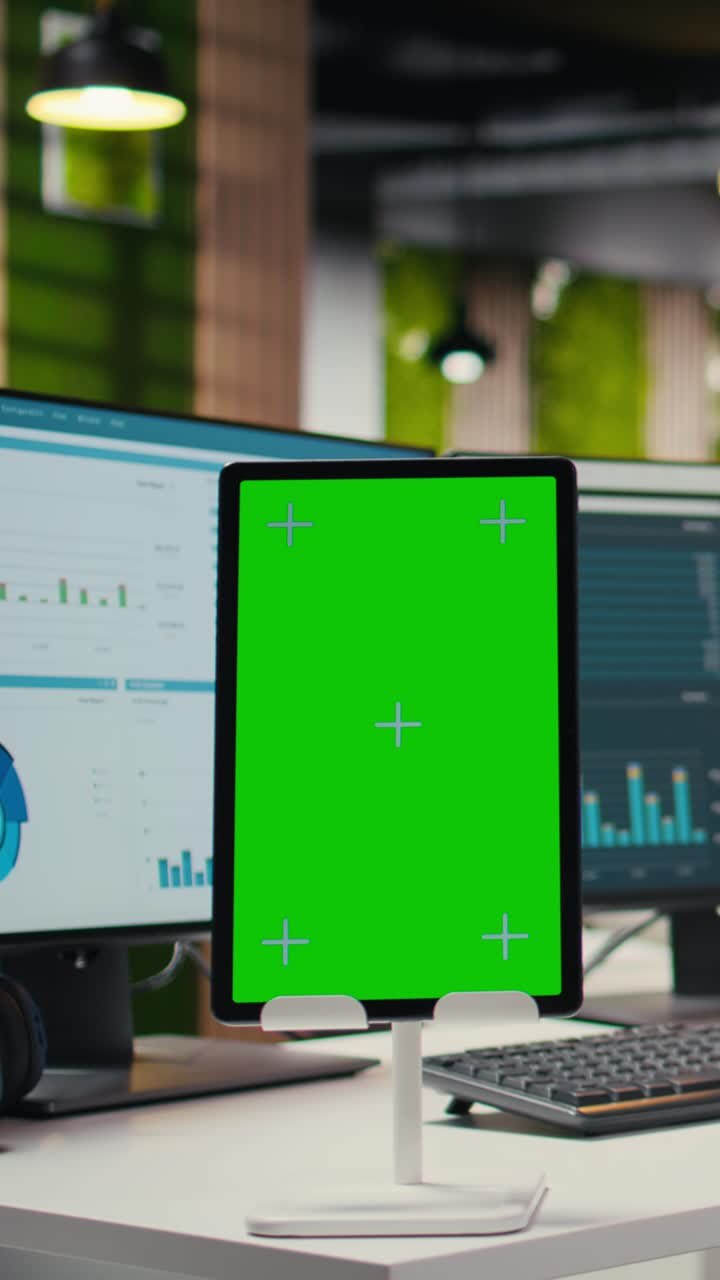 Video verticale. Ufficio moderno e vuoto mostra uno schermo verde su un tablet alla postazione di lavoro.