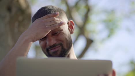 man in park having headache after work, massaging temples