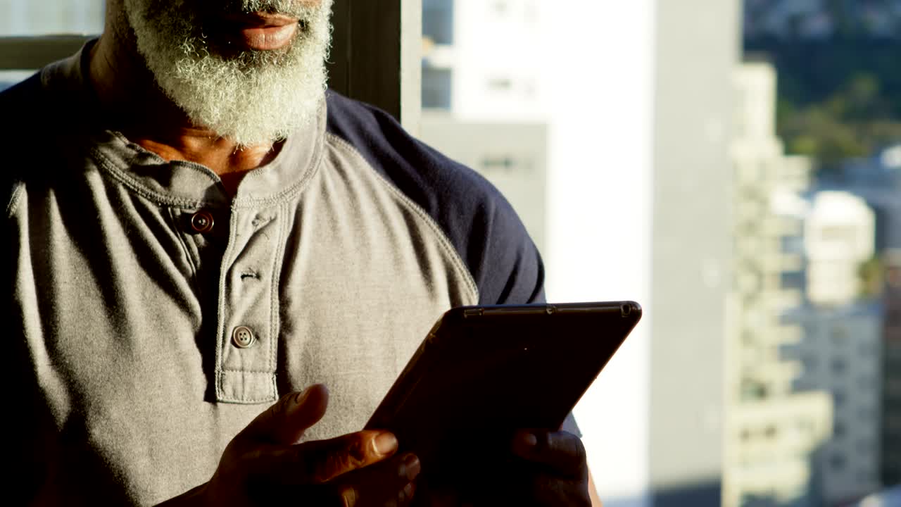 hombre mayor que usa tableta digital en casa 4k