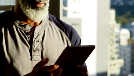 Senior man using digital tablet at home 4k