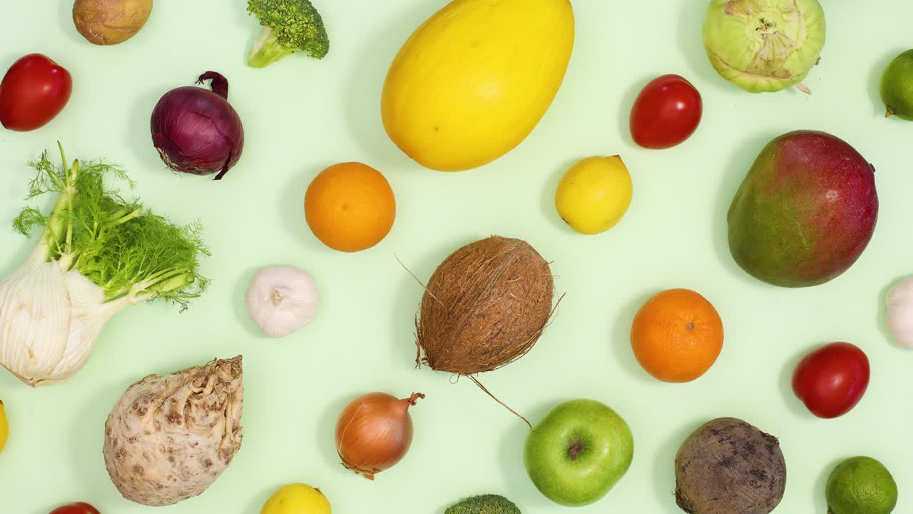 patrón creativo hecho de frutas y verduras moverse arriba y abajo en fondo verde claro. detener el movimiento