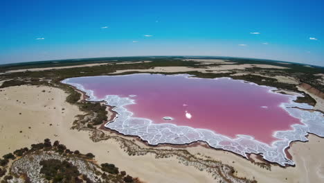 aerial view of a pink salt lake with white shoreline formations