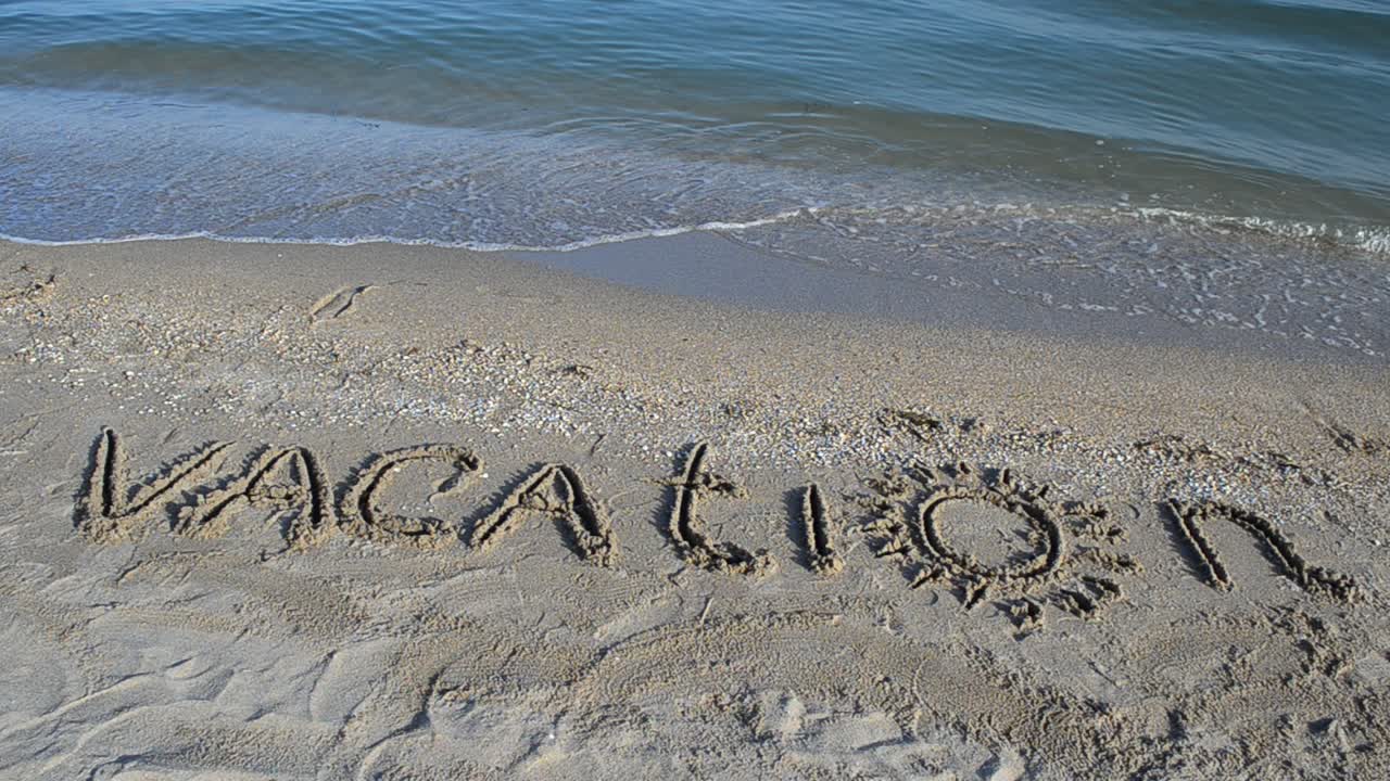 The inscription Vacation on sand. Inscription on sand
