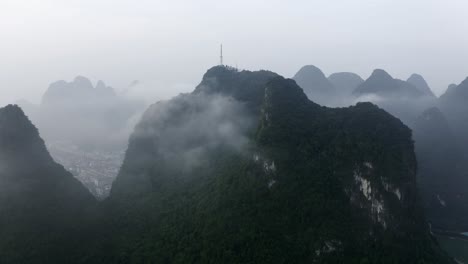las montañas de yangshuo 4k drone empujan desde la torre de televisión por encima de las nubes de niebla