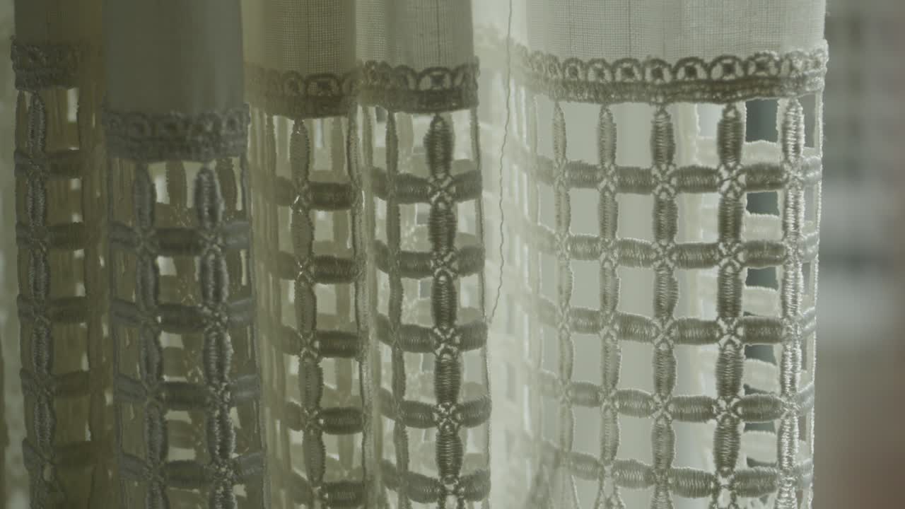 Tende leggere che si muovono dolcemente con la luce naturale del sole che filtra da una finestra. Atmosfera interna calma che cattura il comfort domestico, il design degli interni minimalista e uno spazio abitativo tranquillo.